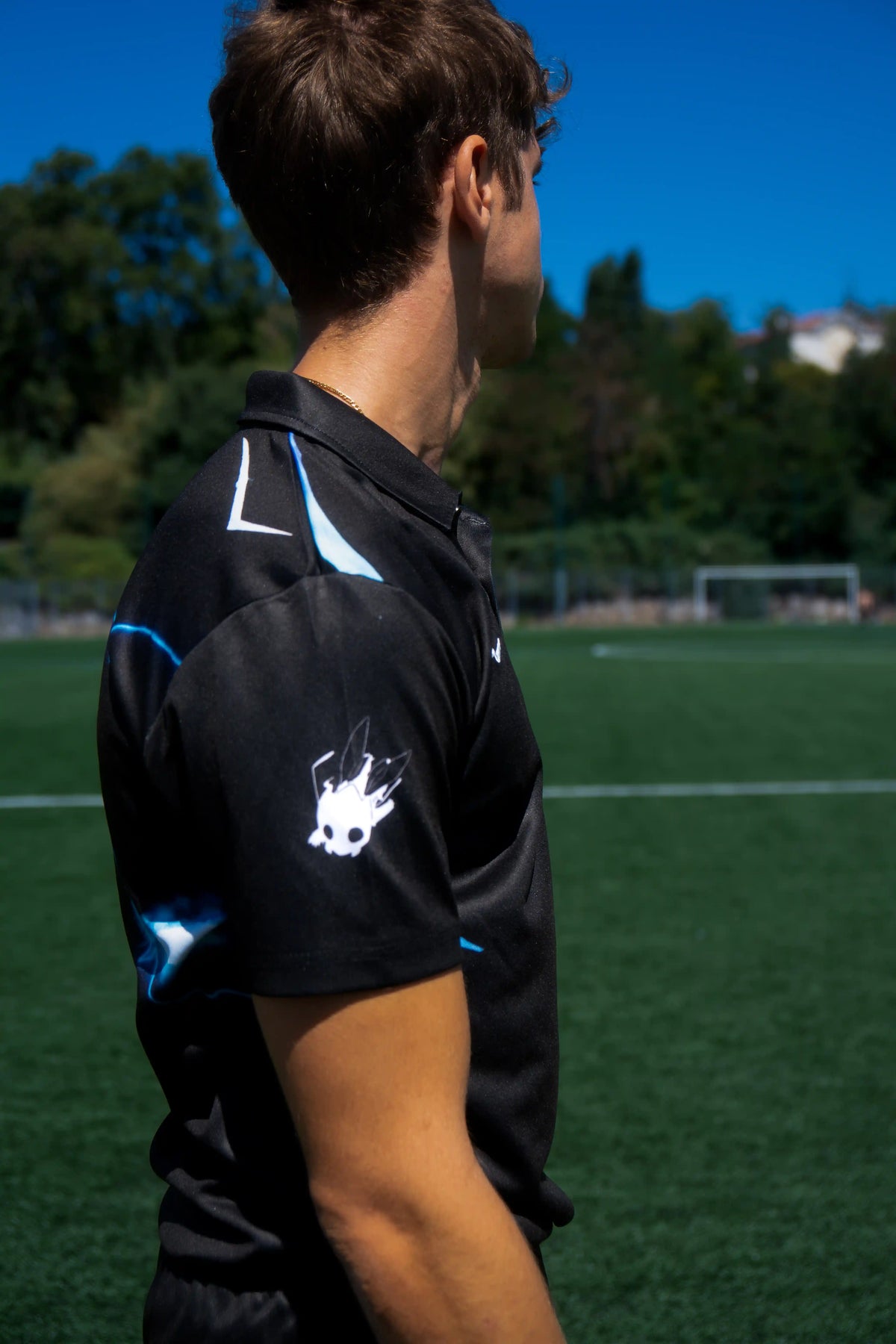 Maillot de foot Inazuma Arise noir porté en extérieur, look streetwear