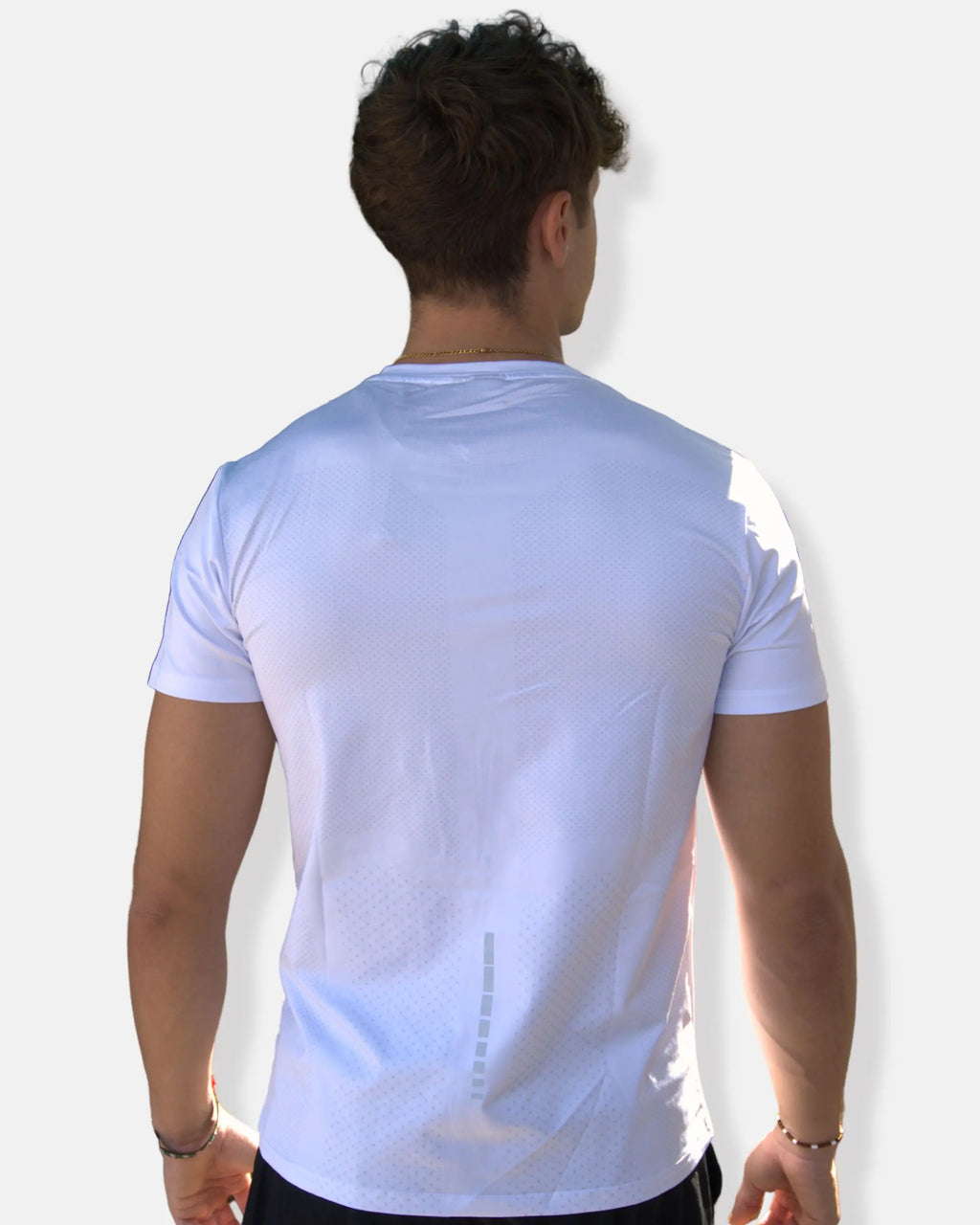 Dos du t-shirt de sport blanc avec zones micro-perforées et bande réfléchissante