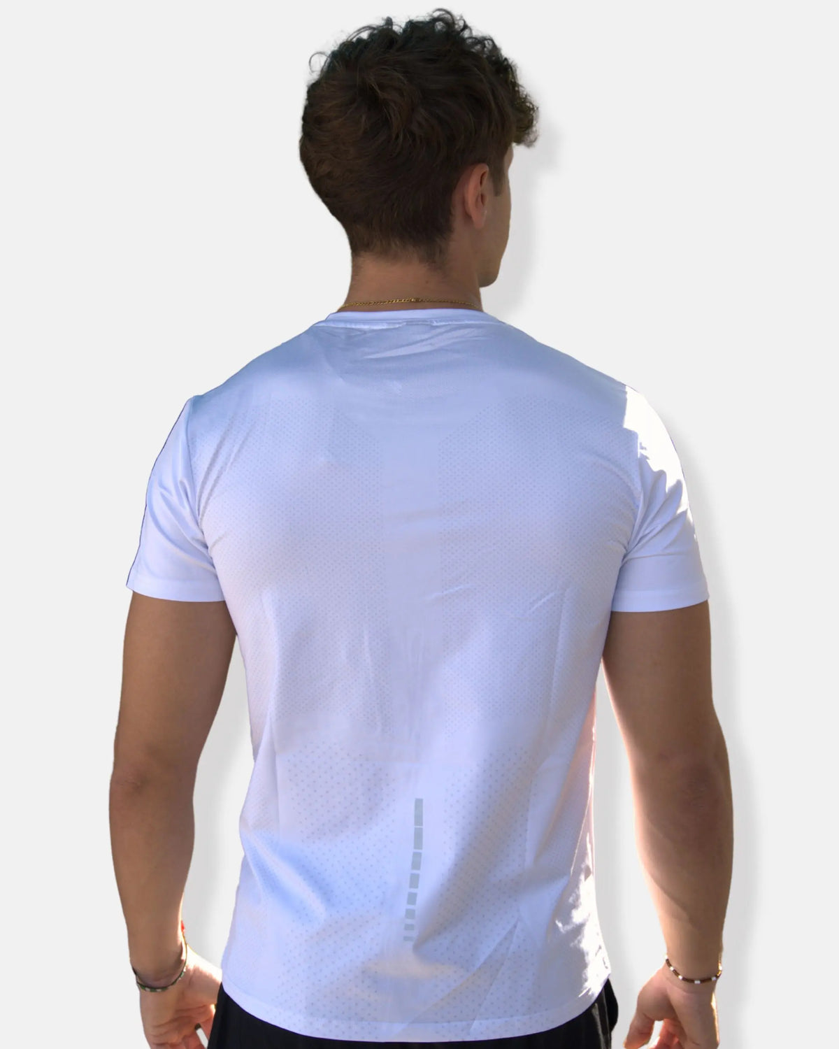 Dos du t-shirt de sport blanc avec zones micro-perforées et bande réfléchissante