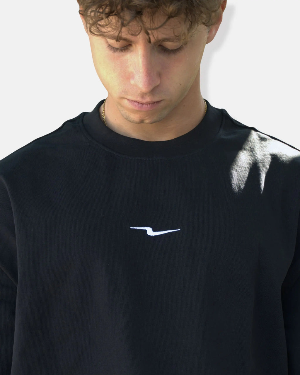 Zoom sur le logo éclair brodé blanc du t-shirt oversize noir