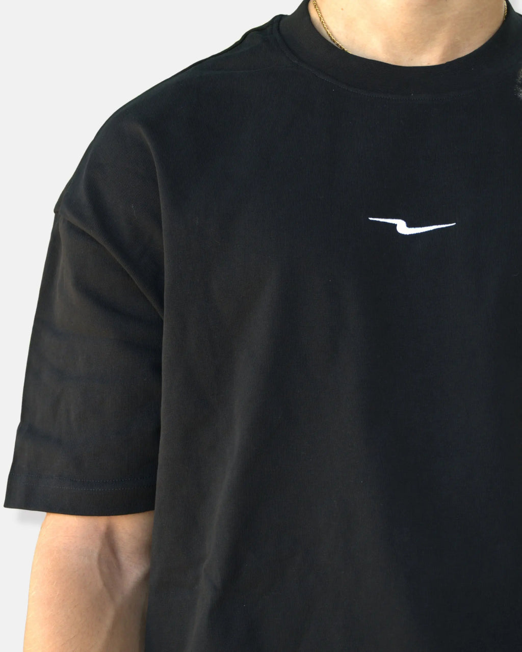 T-shirt oversize noir, détail du col côtelé et de l'épaule tombante