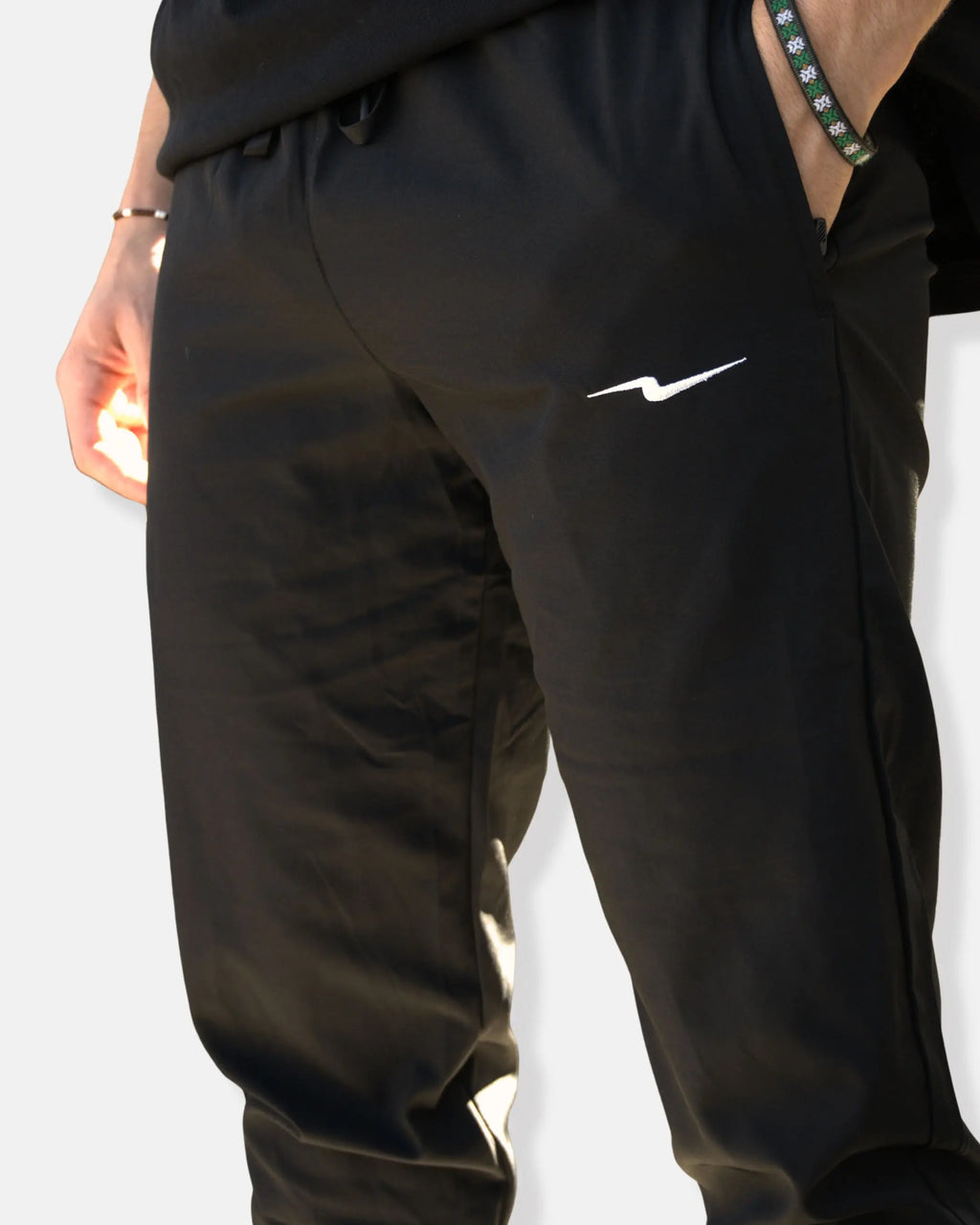 Pantalon de sport noir avec poches zippées et ceinture élastique à cordon