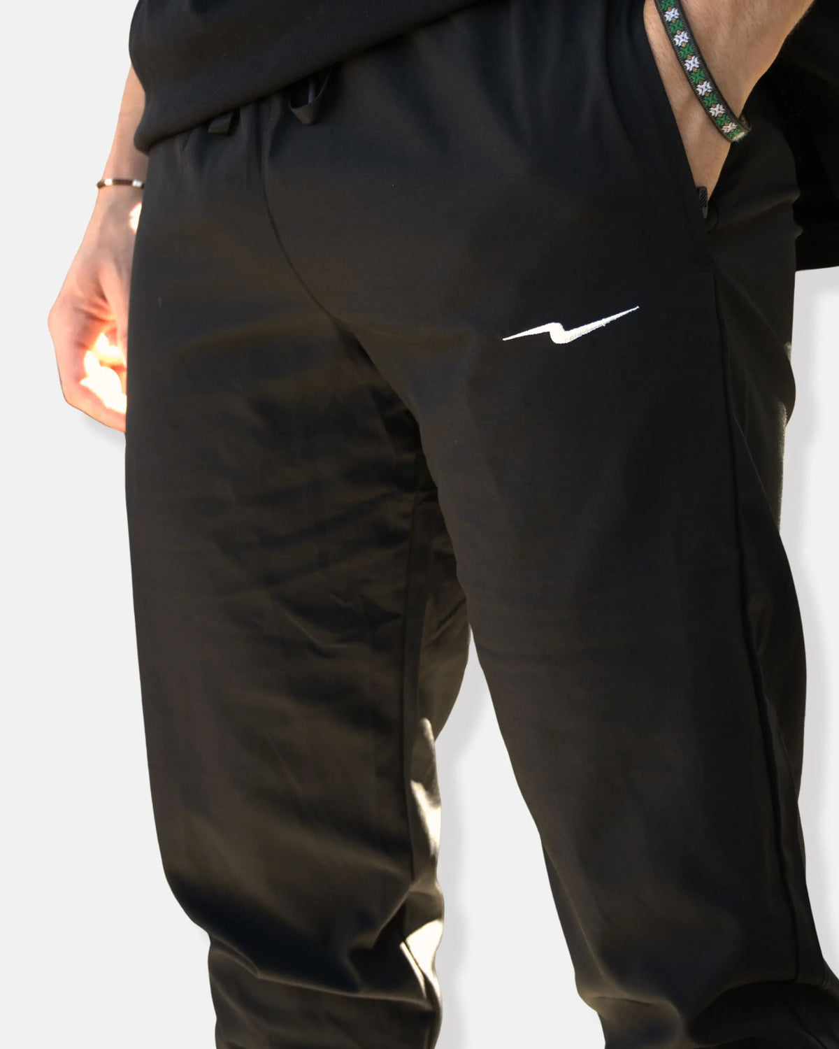 Pantalon de sport noir avec poches zippées et ceinture élastique à cordon