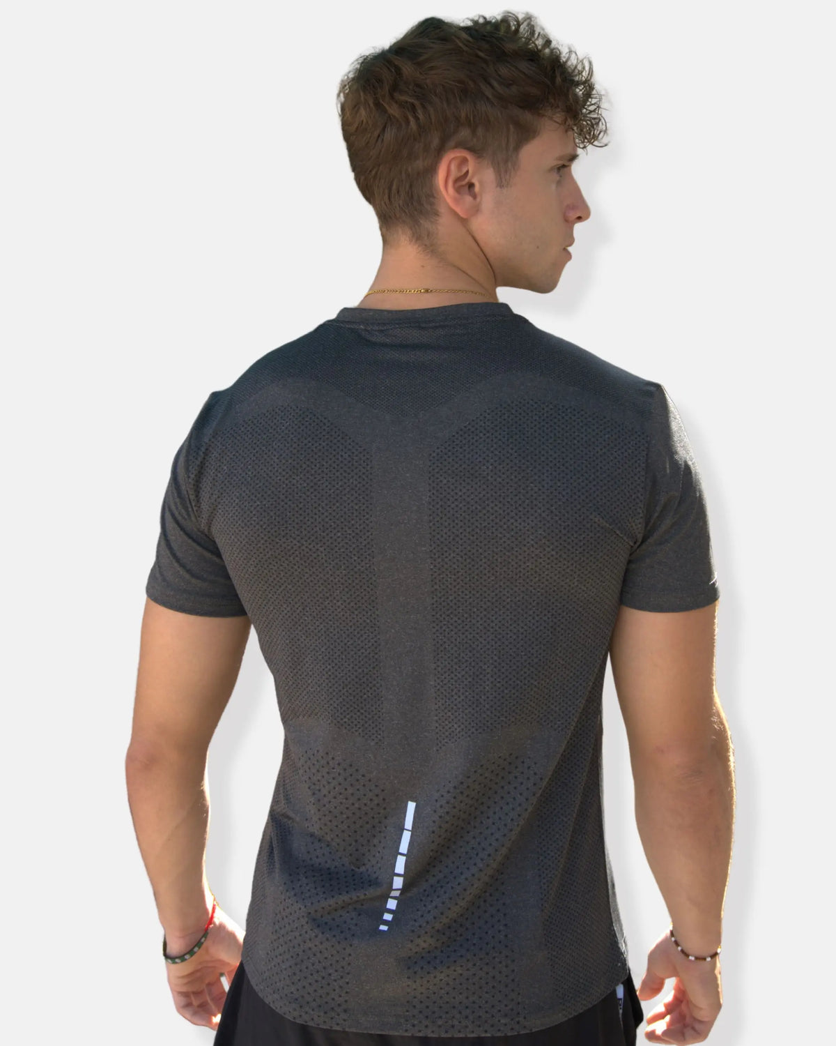 Dos du t-shirt de sport gris avec zones perforées et bande réfléchissante