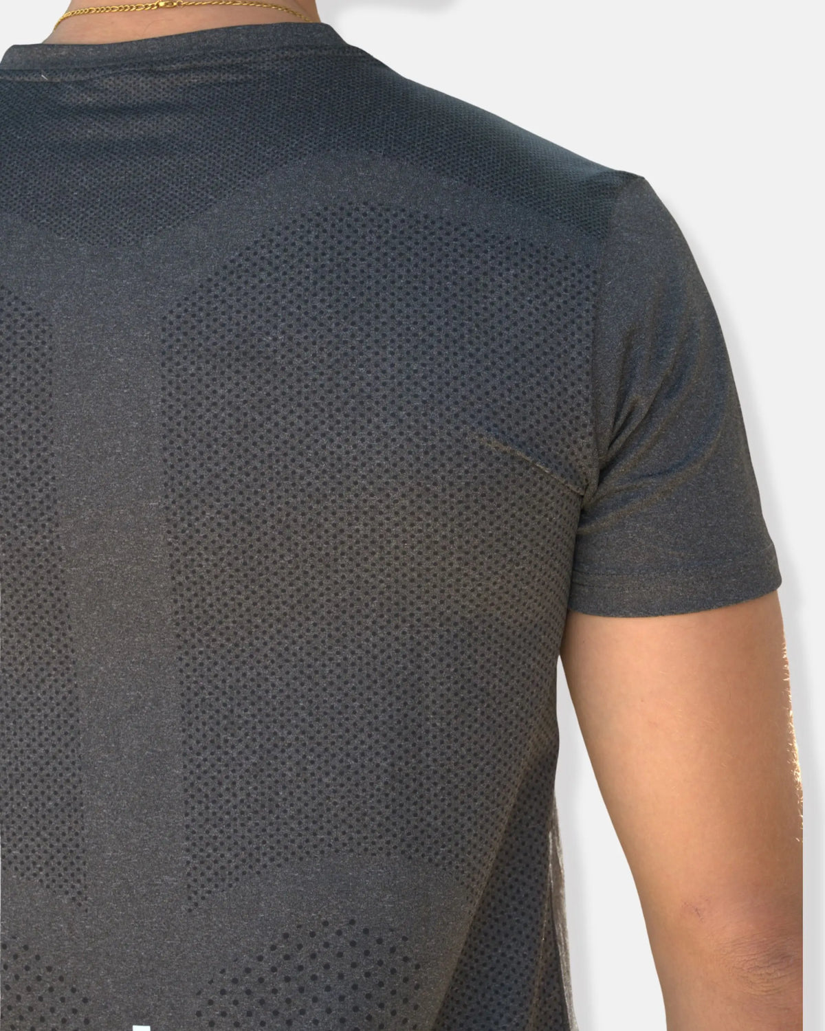 Détail du tissu perforé respirant au dos du t-shirt de sport gris